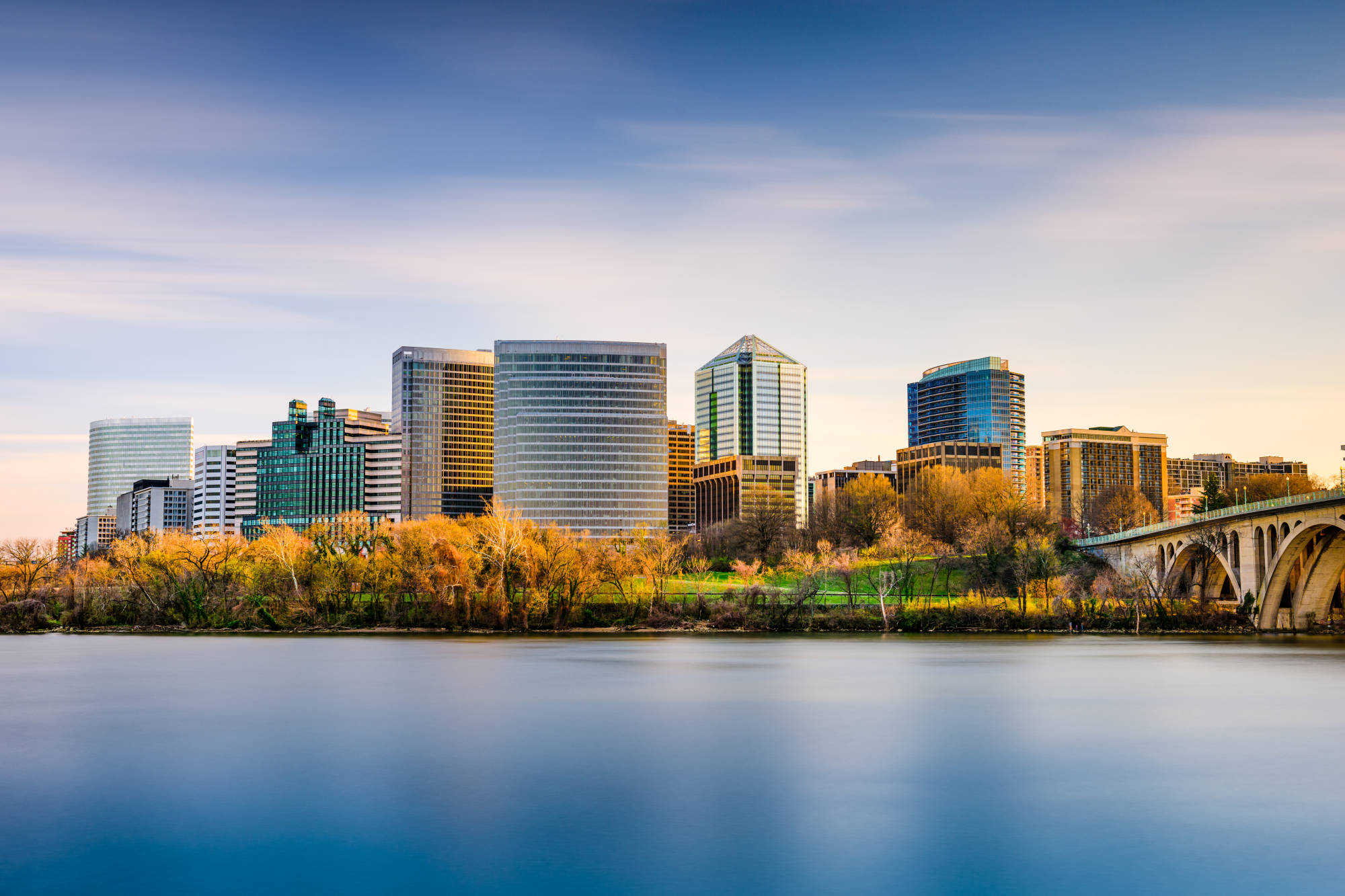 Arlington skyline, riverside trees and an arched bridge beside the Potomac River